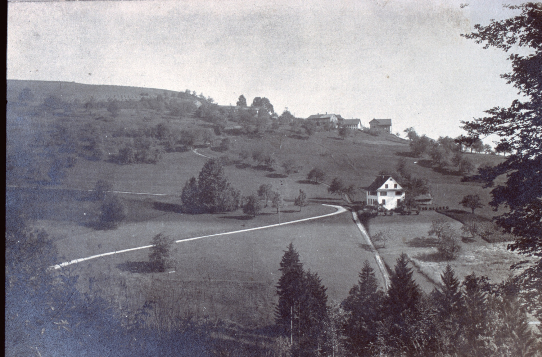 Schulhaus Berg. Gut sichtbar die alte Str. Kleinbäretswil-Ferenwaltsberg, die neue Str. mit weniger Steigung wurde 1848 gebaut, eine Notstandsarbeit, an der vor allem Familienväter beteilgt waren.