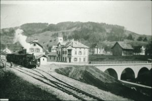 Bahnhof Bäretswil mit Dampfloki, Restaurant Bahnhof und der neuen Bahnhofbrücke. Hinten Pfarrhaus und Zehnten Scheune.