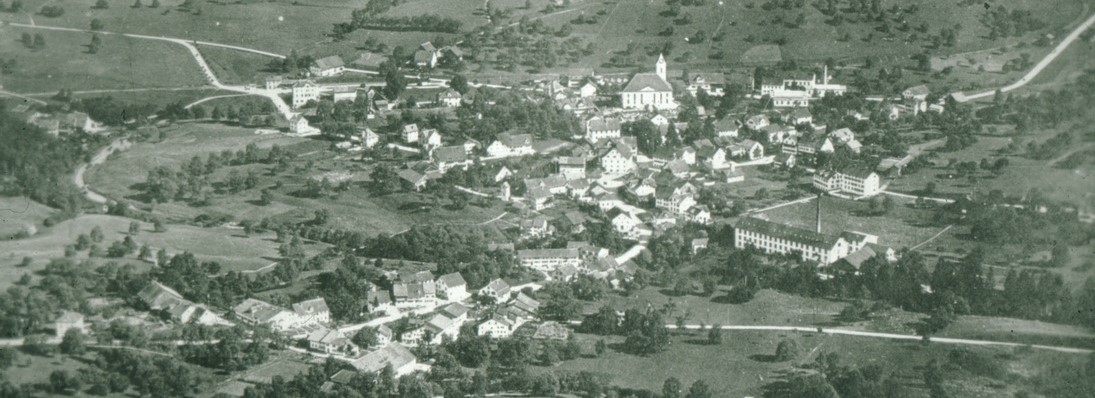 Flugaufnahme Bäretswil aus 400 m Ad Astra. imVG: Oberdorf - Spörri-Fabrik / Mitte: Bahnhof - Kirche - Baumastrasse / imHG: Alte Engelsteinstrasse